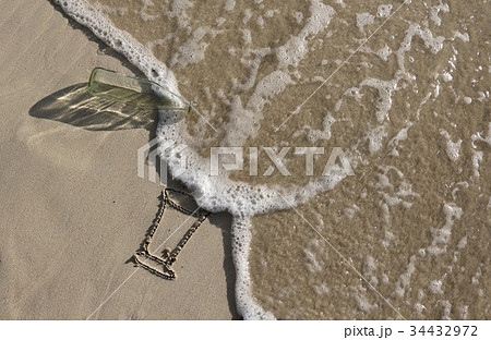 Glass bottle trash on the beac 34432972