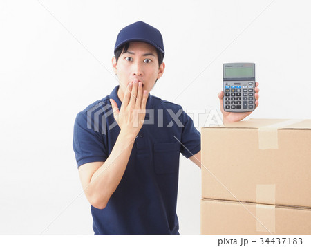 ダンボール箱と電卓を持って驚く作業員 34437183