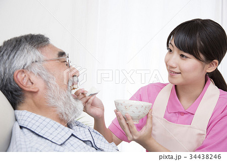 高齢者介護 介助シーン 食事介助 ベッド上 寝たきり 介護士の写真素材