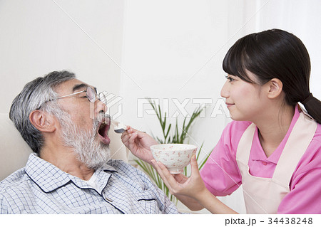 高齢者介護 介助シーン 食事介助 ベッド上 寝たきり 介護士の写真素材