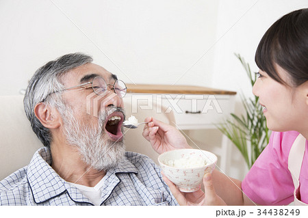 高齢者介護 介助シーン 食事介助 ベッド上 寝たきり 介護士の写真素材