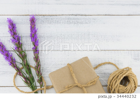 Brown gift box and rope with violet liatris flower Brown gift box and rope with violet liatris flower 34440232