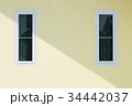 wall yellow house with two windows. 34442037