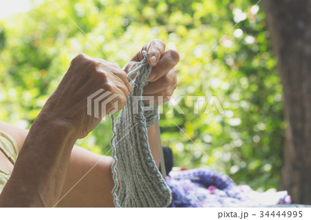 The old woman knits woolen clothes. 34444995