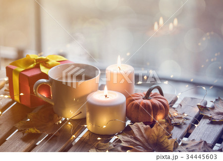 cup of coffee or tea near a pumpkin and candles 34445603