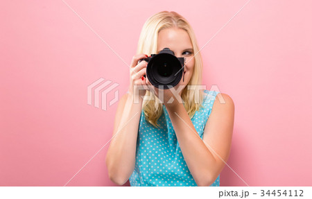Young woman comparing professional camera Young woman comparing professional camera 34454112
