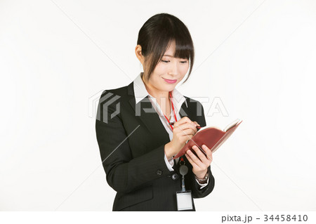 時間やスケジュール管理はビジネスパーソンの基本。ビジネスウーマンは常にペンと手帳を持参し、予定を確認 34458410
