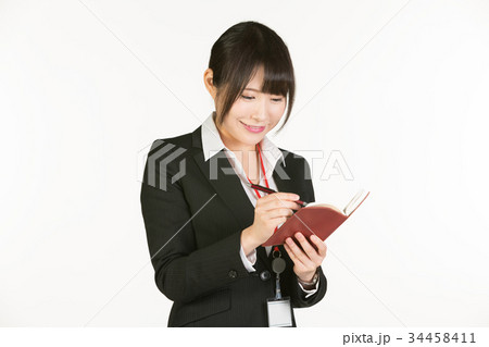 時間やスケジュール管理はビジネスパーソンの基本。ビジネスウーマンは常にペンと手帳を持参し、予定を確認 34458411