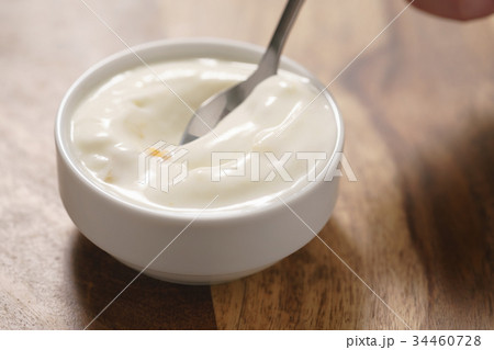 eating peach yogurt from white bowl eating peach yogurt from white bowl 34460728