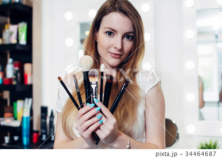 Portrait of female beautician holding a set of 34464687