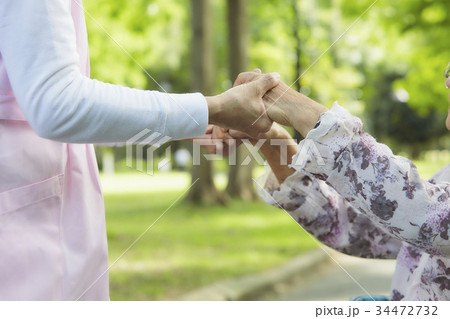介護 車いすの女性と手をつなぐ 介護 車いすの女性と手をつなぐ 34472732