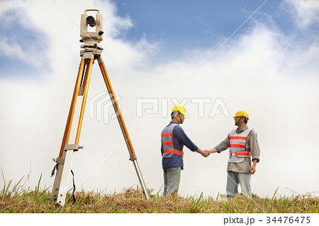 two Surveyor engineers handshaking on the field 34476475
