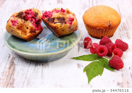 Fresh baked muffins with chocolate and raspberries 34476518
