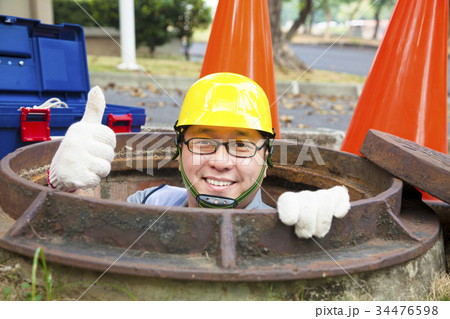 sewerage worker in the manhole with thumb up sewerage worker in the manhole with thumb up 34476598