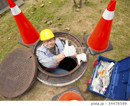 sewerage worker in the manhole with thumb up 34476599