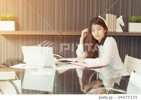 A Stressed Asian business woman using a laptop 34477335