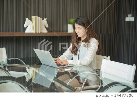 An Asian business woman using laptop in office An Asian business woman using laptop in office 34477506