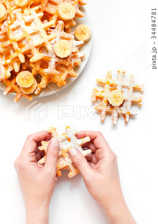 Woman hands holding the fresh homemade waffles Woman hands holding the fresh homemade waffles 34484781