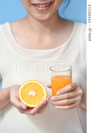 Woman holding sliced orange with Orange juice. 34486313
