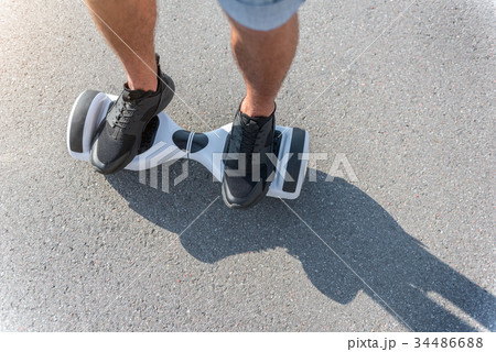 Male feet going on hoverboard at street Male feet going on hoverboard at street 34486688