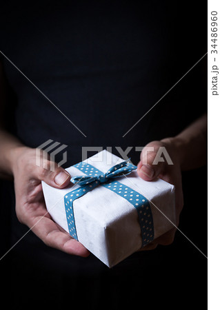 Hands holding a small gift 34486960