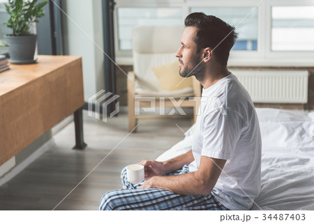 Relaxed guy enjoying espresso in bedroom Relaxed guy enjoying espresso in bedroom 34487403