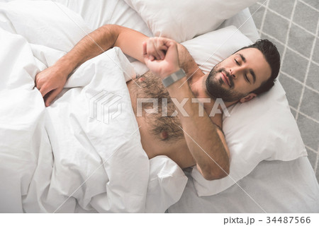 Happy guy checking time on wristwatch in the Happy guy checking time on wristwatch in the 34487566