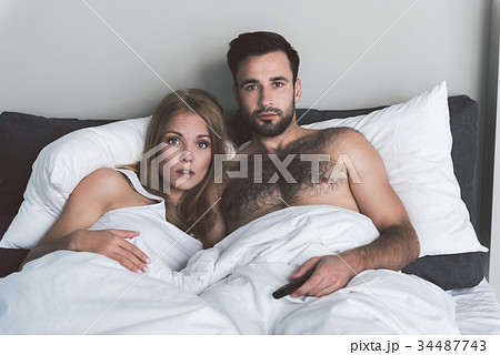 Shocked man and woman are interested in movie plot 34487743