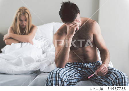 Despaired couple checking results of pregnant test 34487788