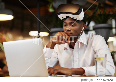 Serious african man i virtual head set, using 34487928