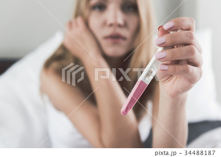Frustrated young woman undergoing pregnant test 34488187