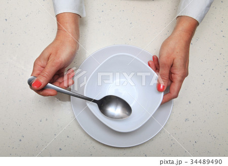 woman holds spoon and plate 34489490