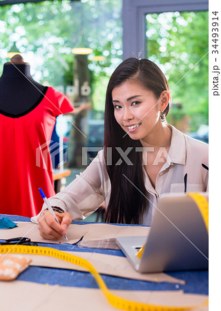 Asian fashion designer preparing drafts for cut Asian fashion designer preparing drafts for cut 34493914