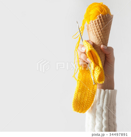 Balls of yarn lie in a waffle cone for ice cream. Balls of yarn lie in a waffle cone for ice cream. 34497891