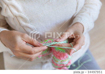 A woman knits a bright colored canvas with spokes A woman knits a bright colored canvas with spokes 34497951