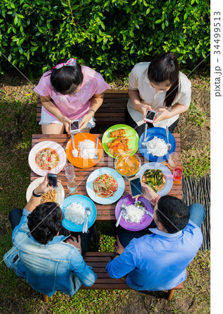 Asian eat on vacation, everyone picks up the phone 34499513