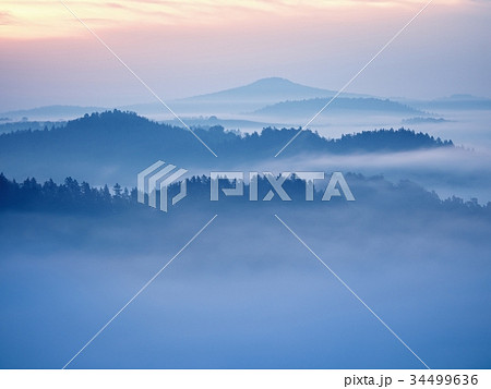 View over edge into valley full of autumnal mist 34499636