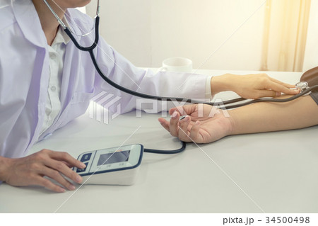 Competent attentive doctor being measuring blood pressure to pat 34500498