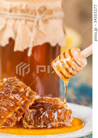 Honey in a pot or jar on kitchen table Honey in a pot or jar on kitchen table 34503277