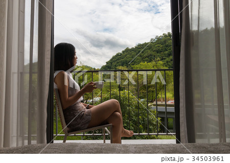 a short hair young woman sitting at the balcony 34503961
