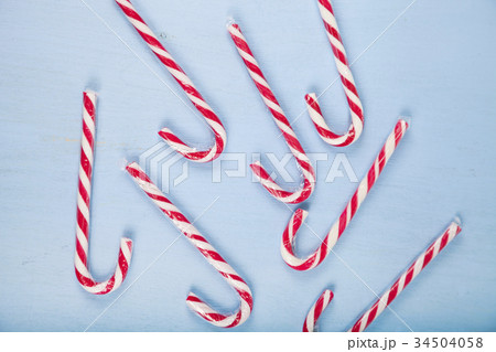 Сandy canes on a  wooden background.  34504058