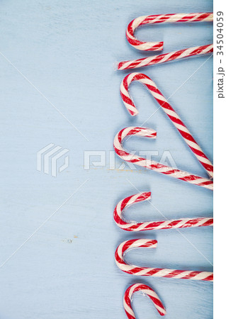 Сandy canes on a  wooden background.  34504059