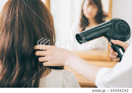 ヘアサロンでブローをする美容師の手 34504242