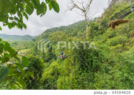 man going on zipline adventure through the forest 34504620