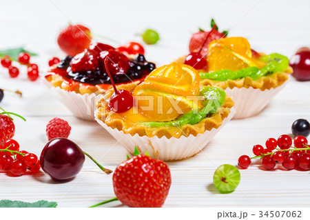 Delicious fruit cake on white wooden background Delicious fruit cake on white wooden background 34507062