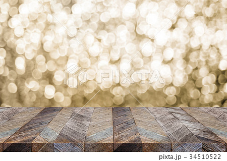 wood table top with blur sparkling gold bokeh 34510522