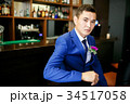 The groom in a blue suit is sitting in a bar with 34517058