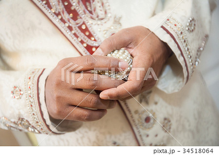 Indian groom holding ring 34518064