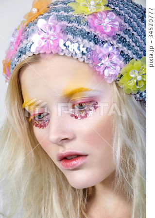 Young girl with colorfull makeup in sparkling hat 34520777
