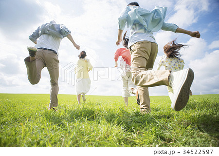 草原を走る大学生の後姿の写真素材